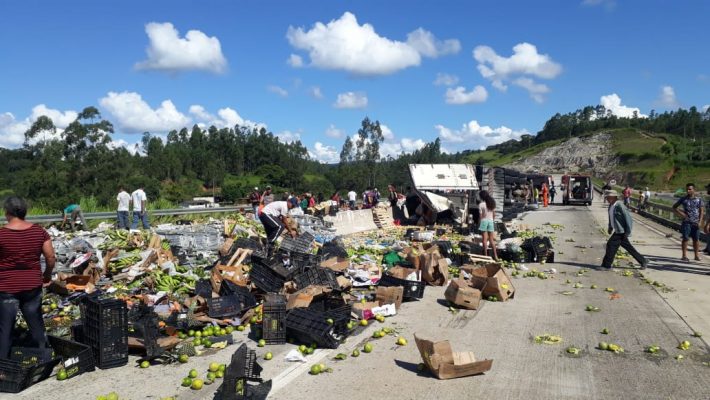 Motorista fica preso às ferragens após caminhão carregado com legumes tombar BR-381