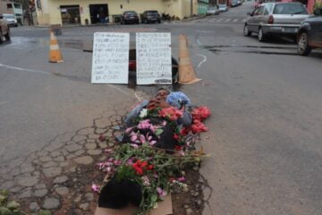 Em protesto inusitado, homem simula velório em buraco da rua Waldemar de Alvarenga Lage