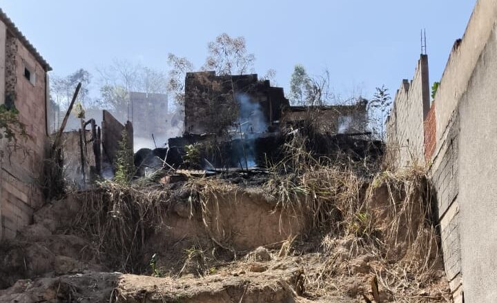 Incêndio em lote vago atinge barracão de madeira no quintal de uma casa no bairro Gabiroba, em Itabira