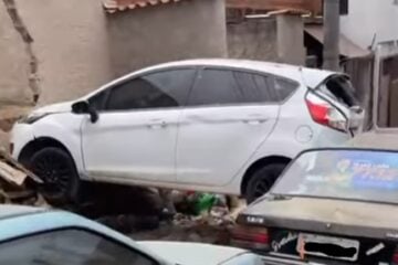 Carro atravessa muro de estacionamento de residencial e atinge veículo que estava para em rua de Itabira