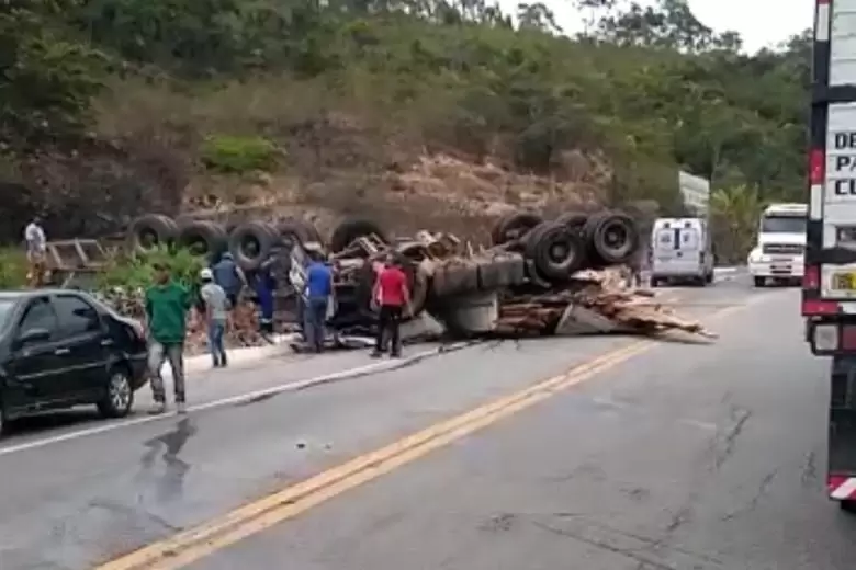 Carreta carregada com madeira tomba na BR-381 e deixa trânsito lento