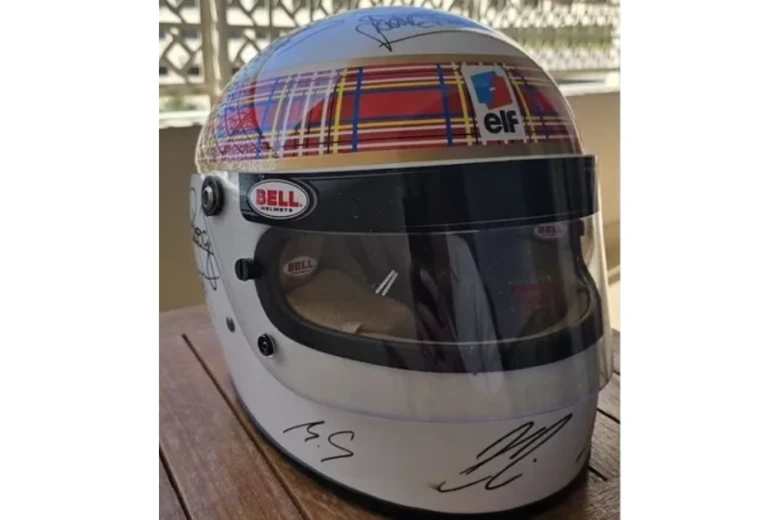 Schumacher assina capacete com ajuda da esposa em rara homenagem na F1 Schumacher assina capacete com ajuda da esposa em rara homenagem na F1