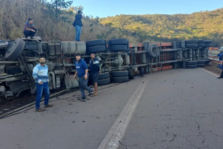 Carreta tomba e bloqueia BR-381 na descida da Serra de Igarapé; motorista fica preso às ferragens Carreta tomba e bloqueia BR-381 na descida da Serra de Igarapé; motorista fica preso às ferragens